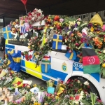 Massvis med blommor på en polisbuss efter terrordådet i centrala Stockholm. När terrorn kom till Sverige - Kristoffer Samsing